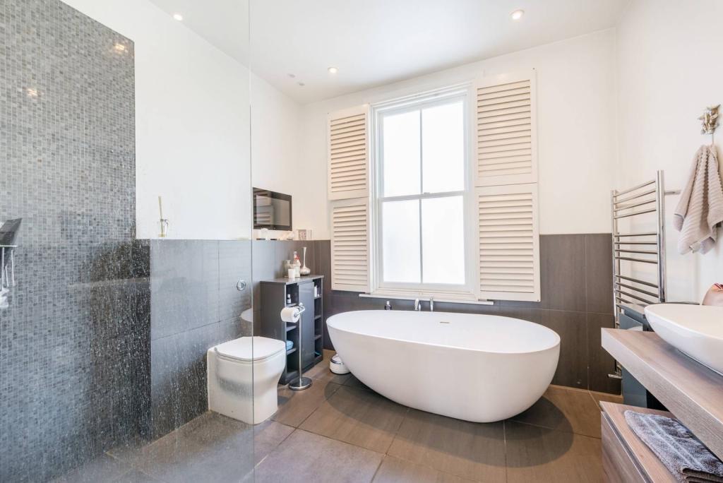 Bathroom with a freestanding bath and shutters