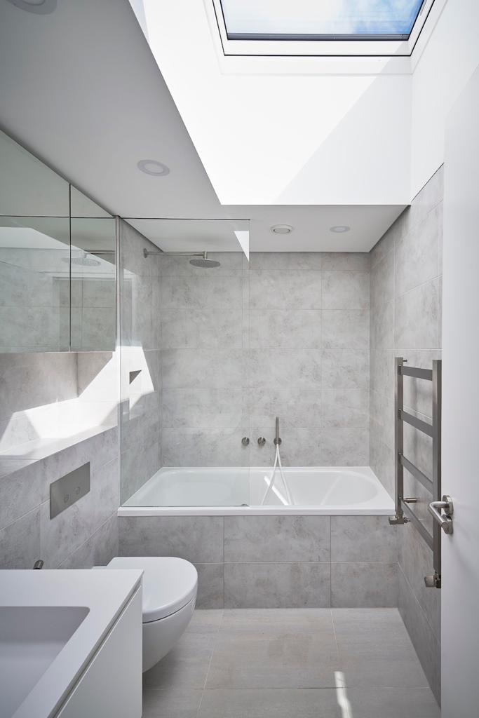 Stone-tiled bathroom under a rooflight