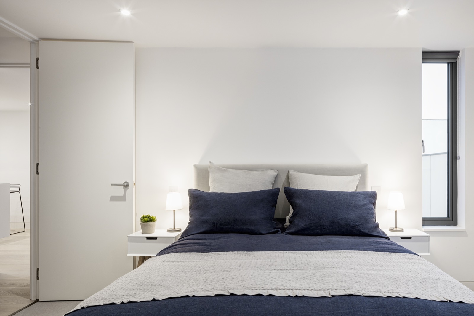 Bedroom with navy bedding and concealed door