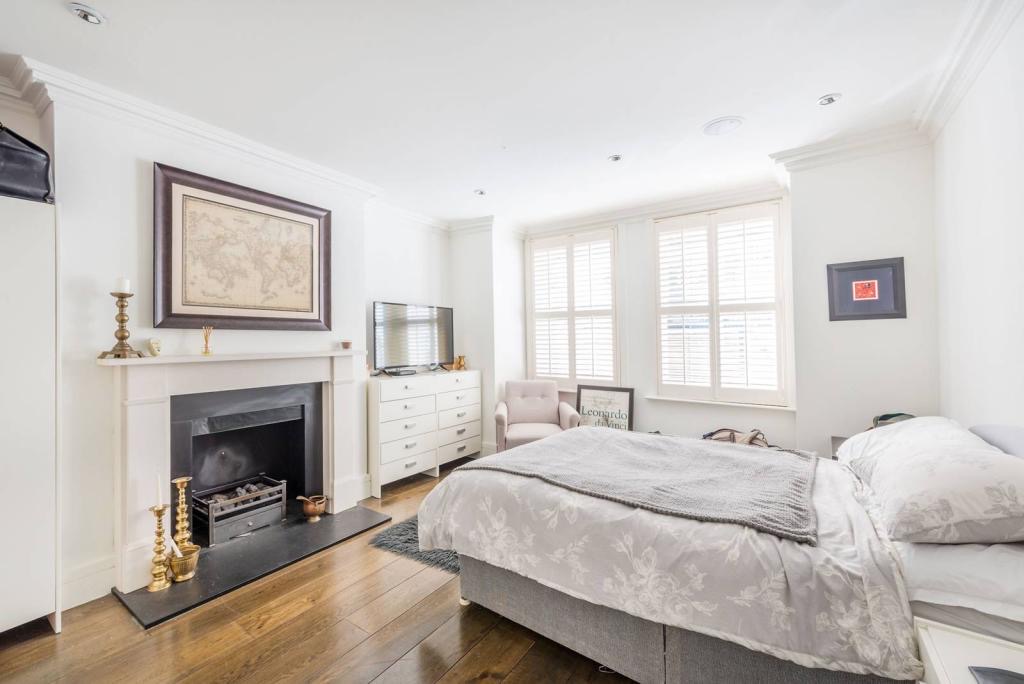 Bedroom with period fireplace and shutters