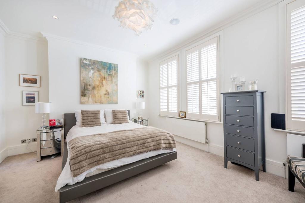 Bedroom with shutters and a low bed