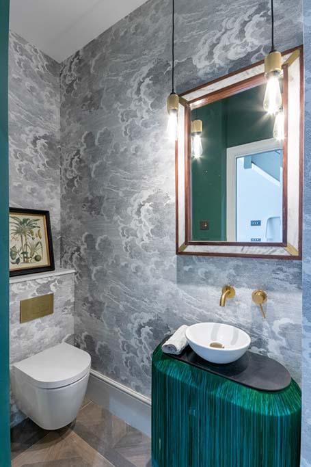 Cloakroom with cloud-pattern wallpaper and brass fittings