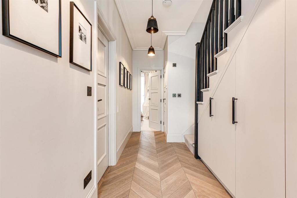 Hallway with herringbone floor and under-stair storage