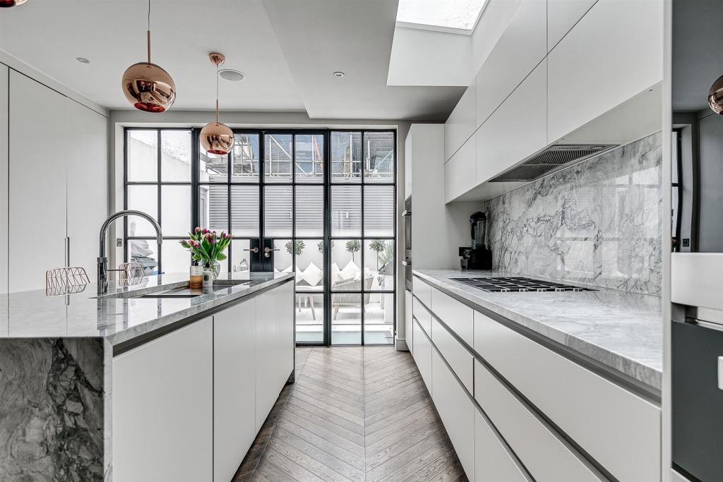 Handleless kitchen with marble worktops and steel-framed doors