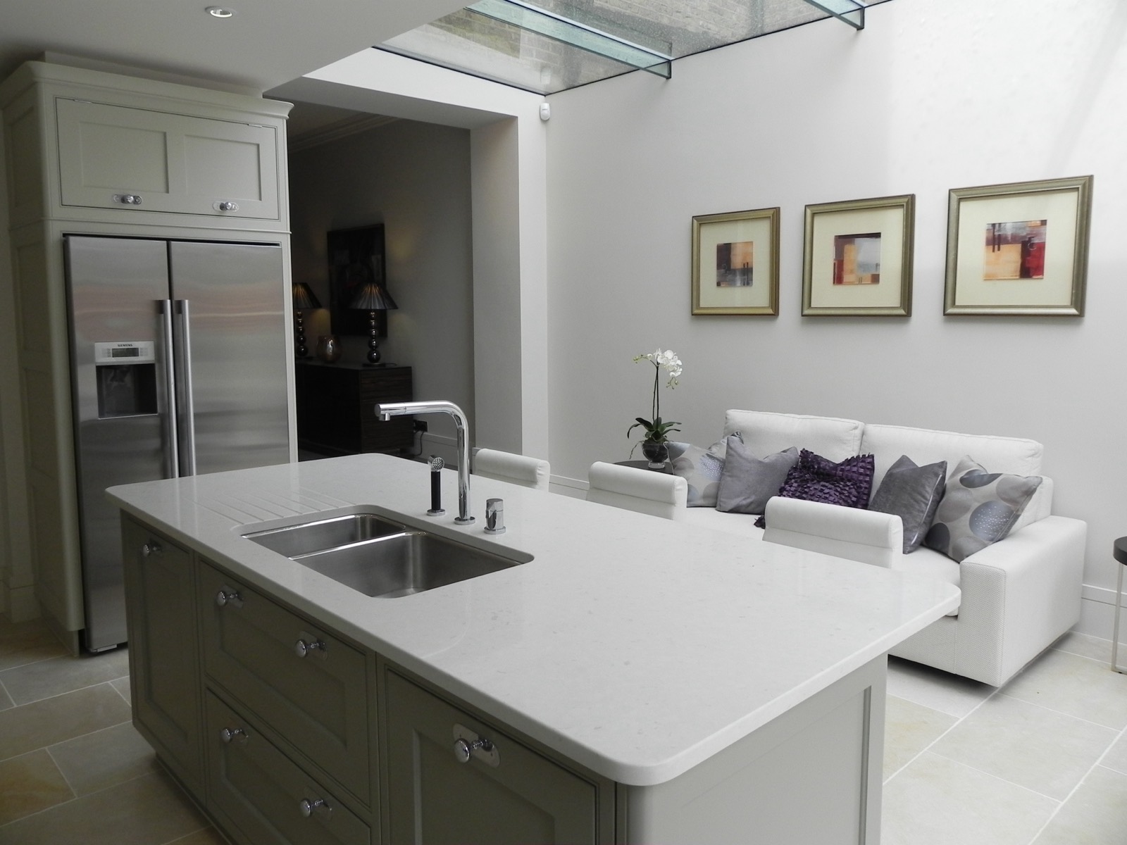 Kitchen island beneath a frameless glass roof