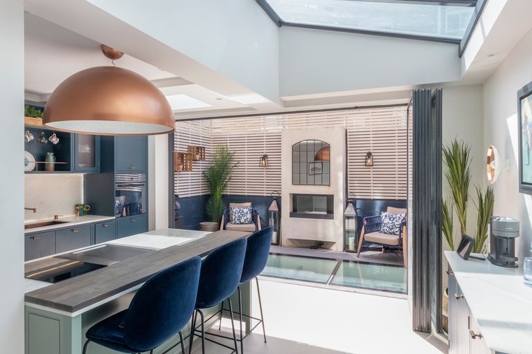 Kitchen with an island opening onto a courtyard with a walk-on glass floor