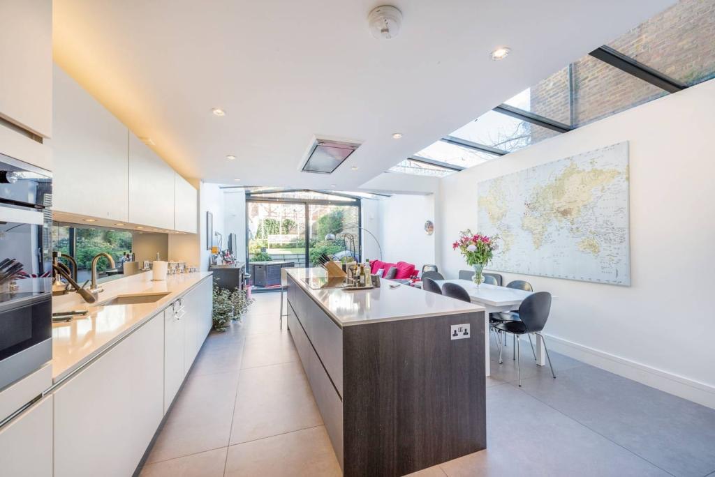 Kitchen with a long island, glazed roof and dining table