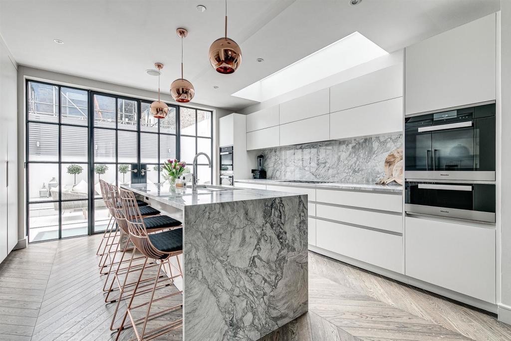 Handleless kitchen with a marble island and steel-framed doors