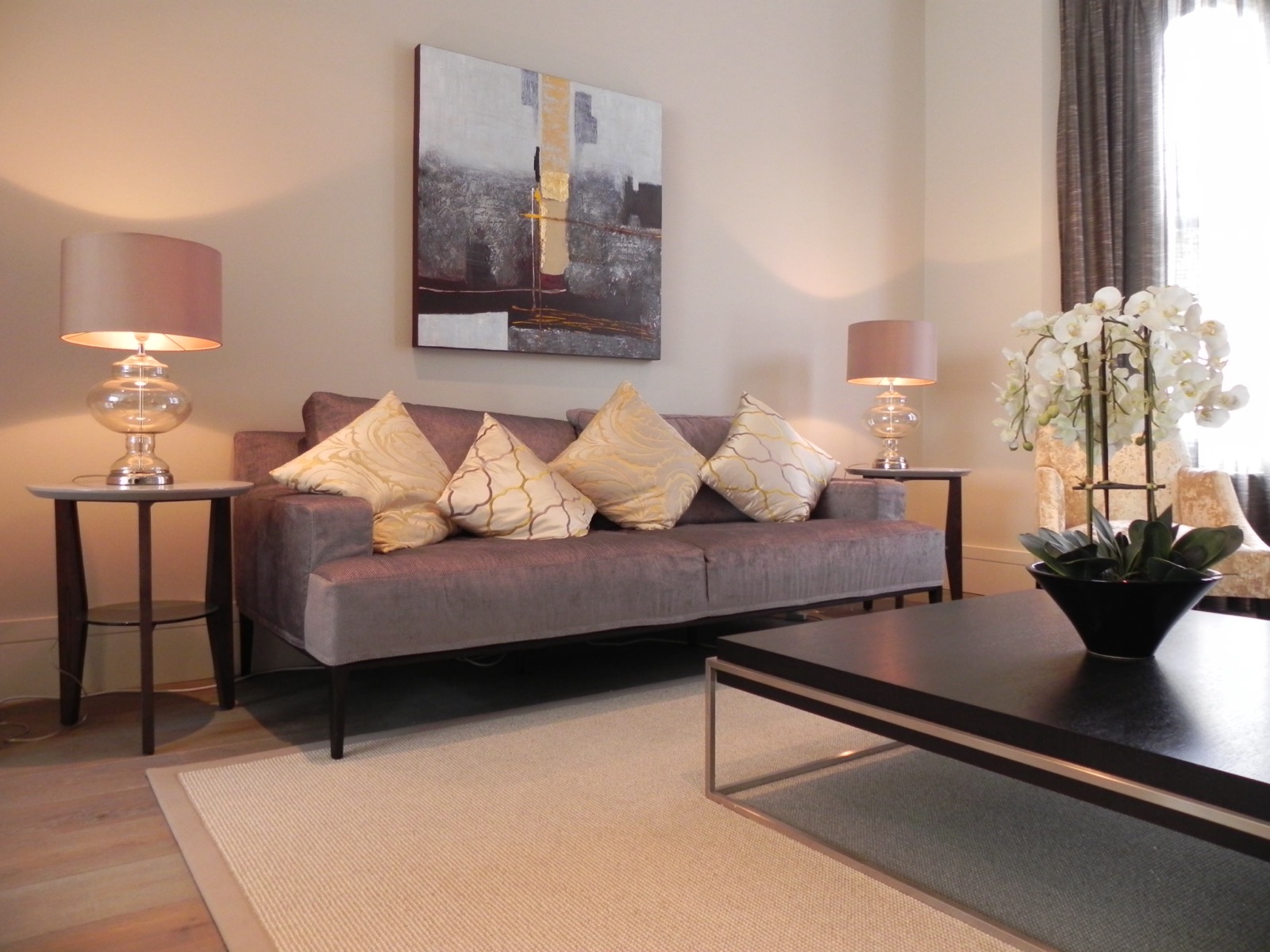 Living room with sofa, lamps and artwork