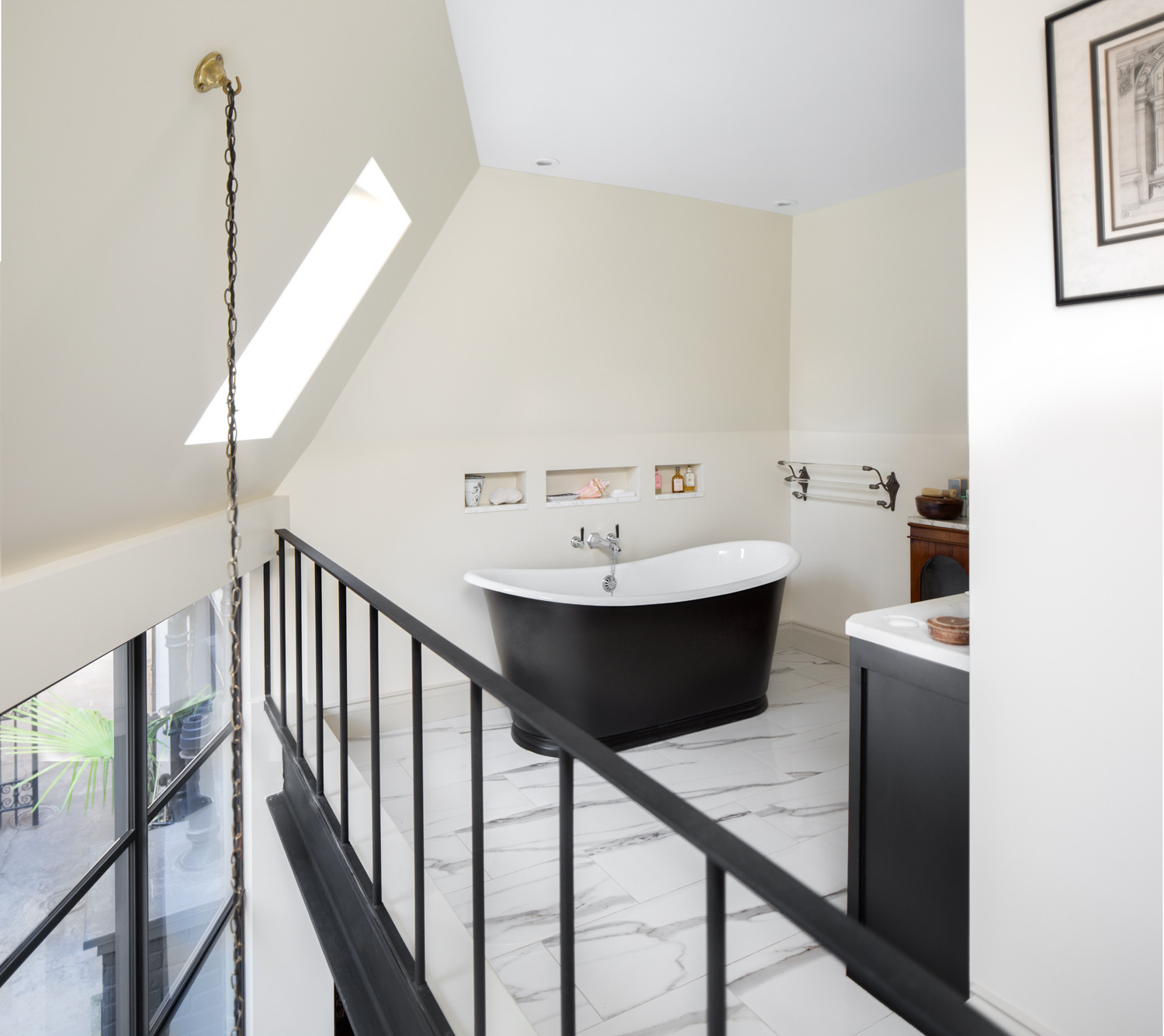 Loft bathroom with a freestanding bath under a rooflight