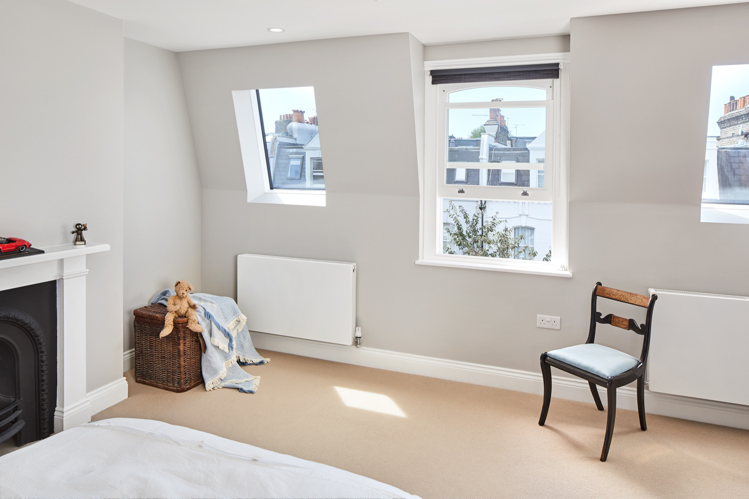 Loft bedroom with rooflights and a fireplace