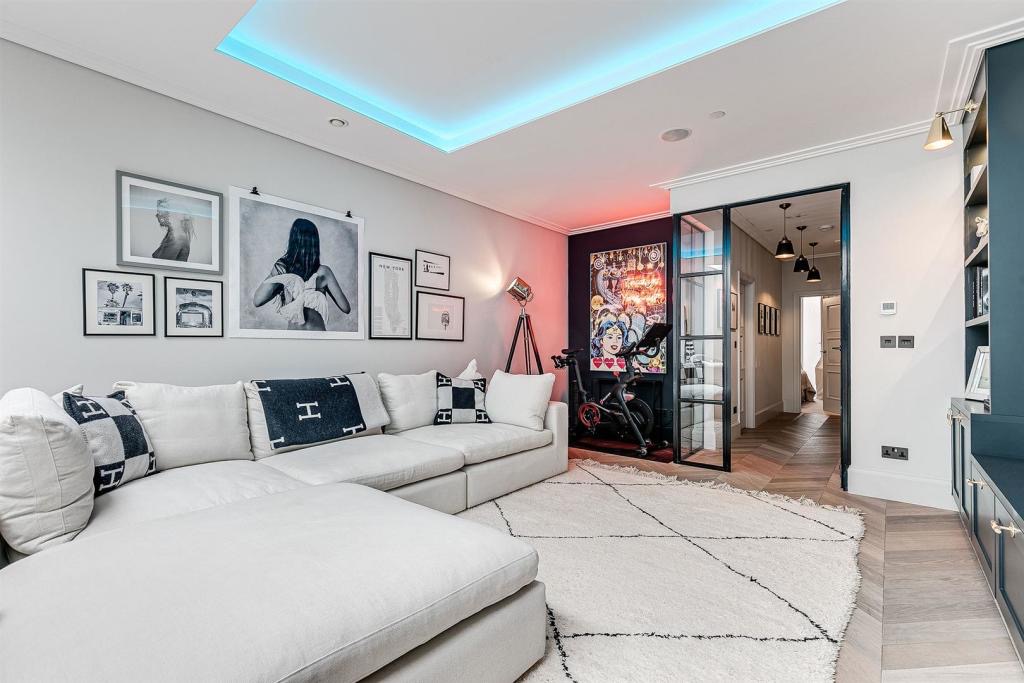 Media room with bespoke cabinetry and a lit ceiling recess