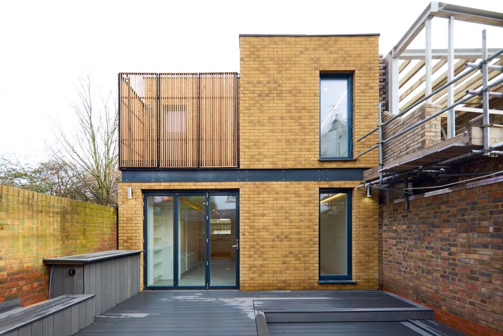 Rear elevation of a new-build brick house with glazed doors
