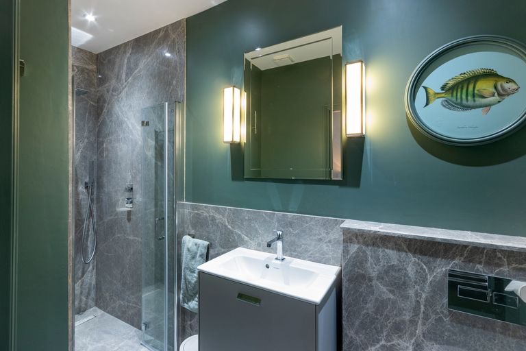 Shower room with marble tiles and green walls
