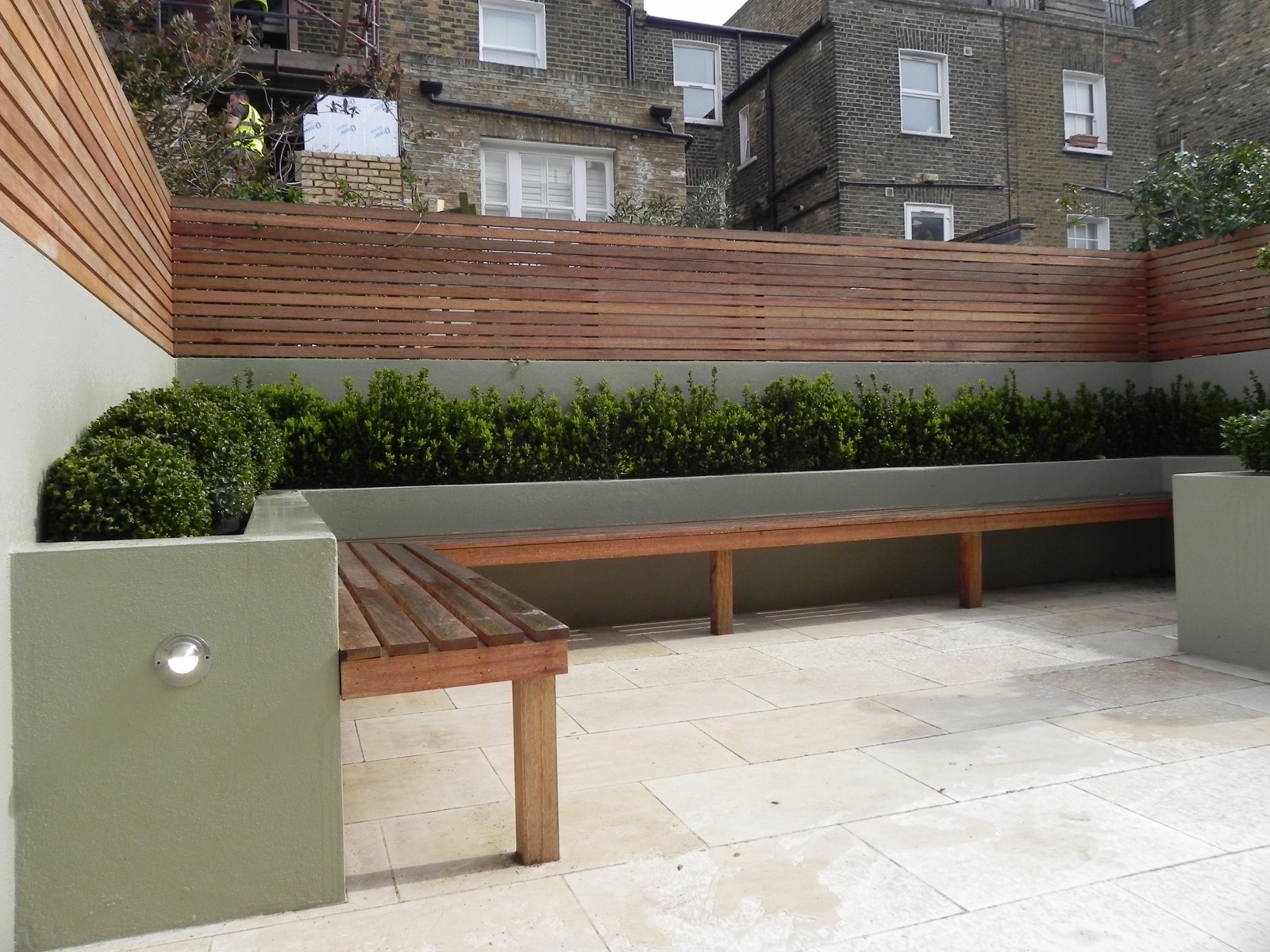 Paved terrace with a built-in bench and cedar fencing