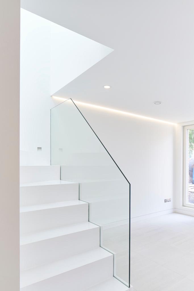 White staircase with a glass balustrade