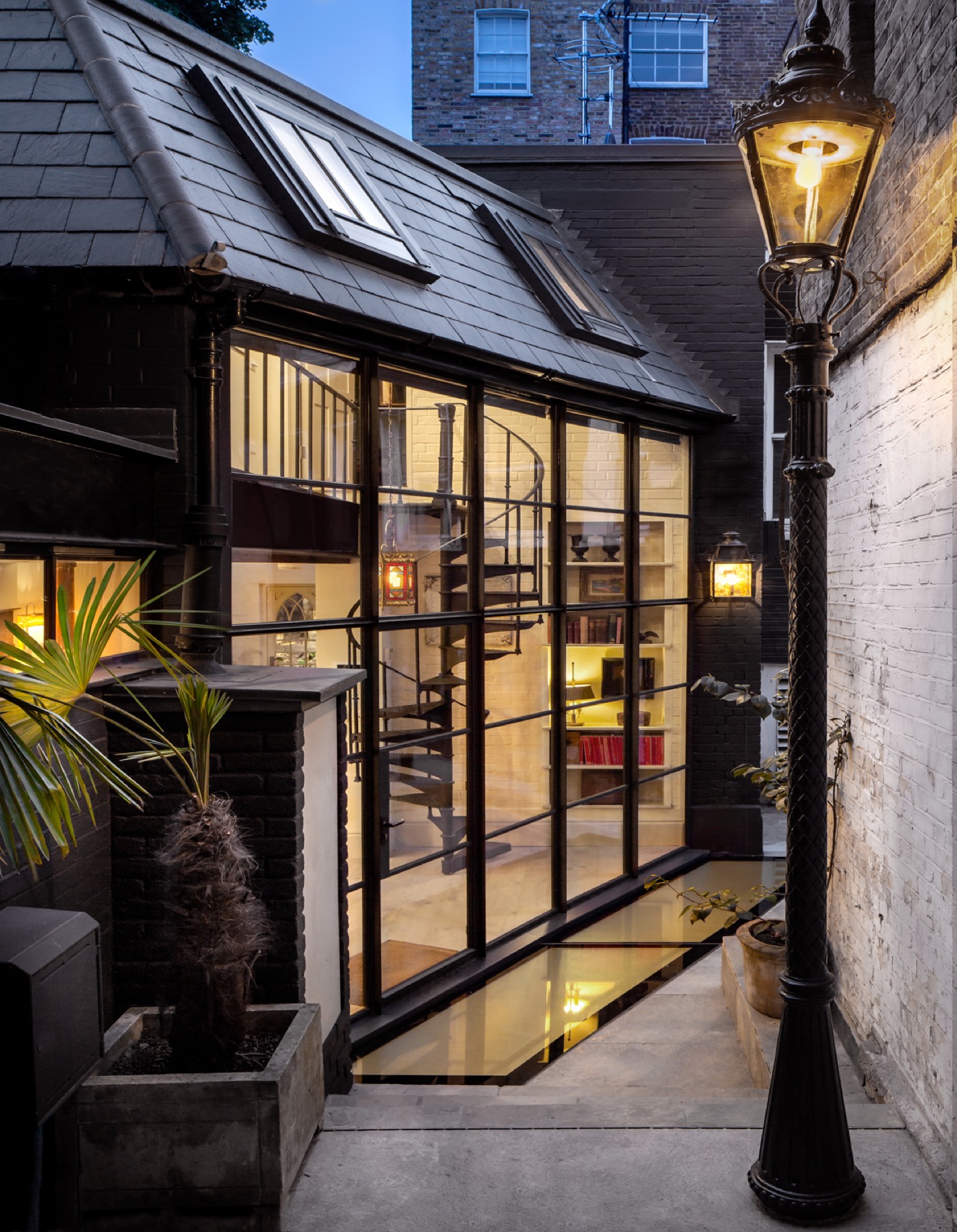 Steel-framed glazed extension lit at dusk, design and build in Emerson Park