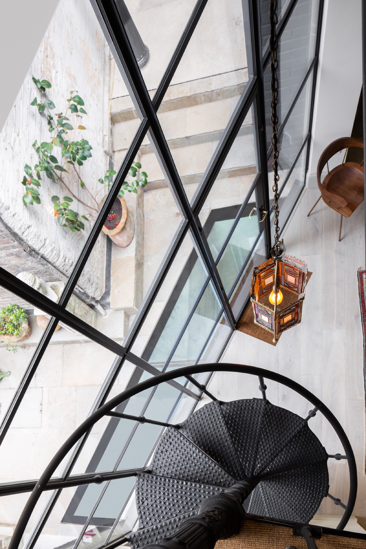 Cast iron spiral staircase beside steel-framed glazing, design and build in Spitalfields and Wapping