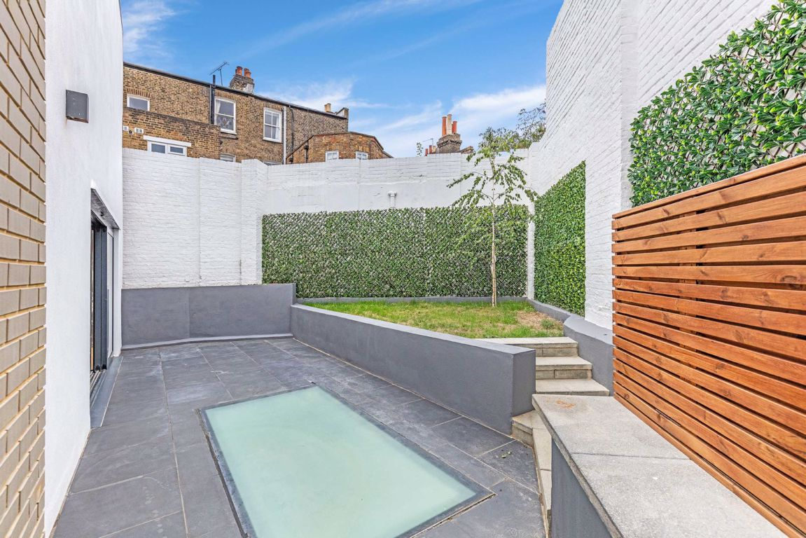Courtyard with walk-on rooflight to the lower ground floor in Hackney
