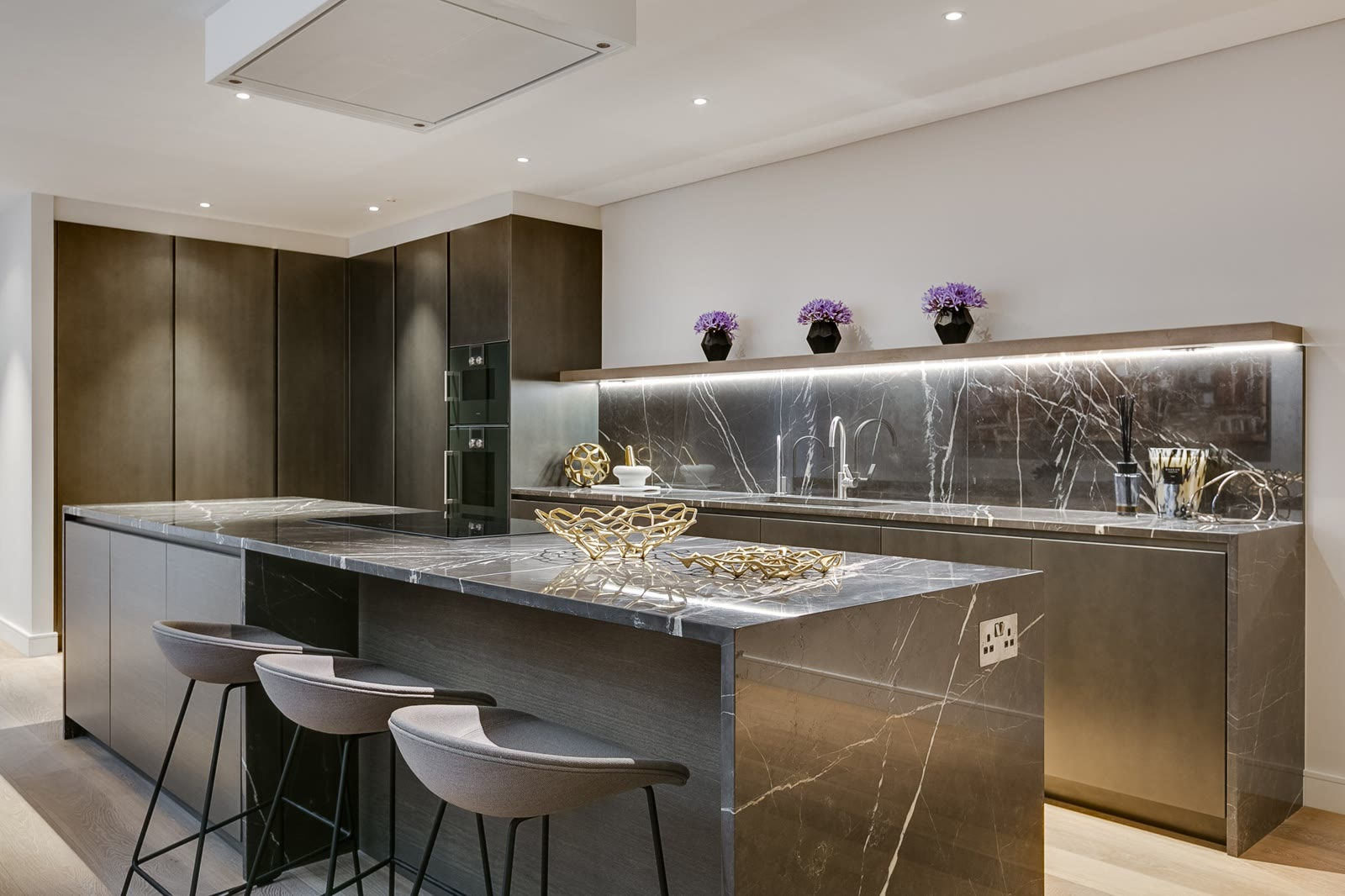 Kitchen with marble island and bar stools in Loughton