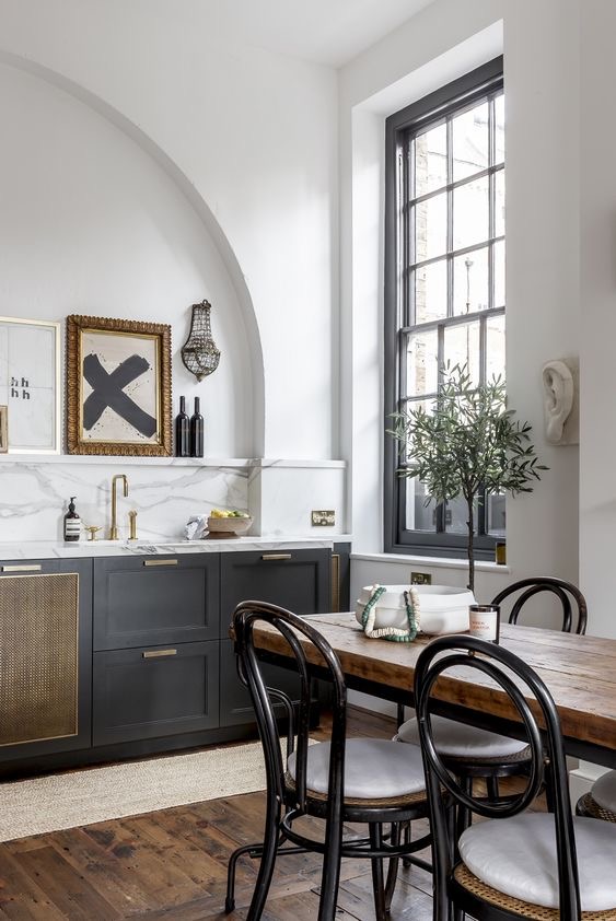 Dark shaker kitchen in a period room with an arched alcove and a tall sash window