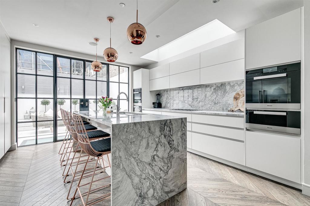 Handleless kitchen with a marble waterfall island, kitchen extension in Emerson Park