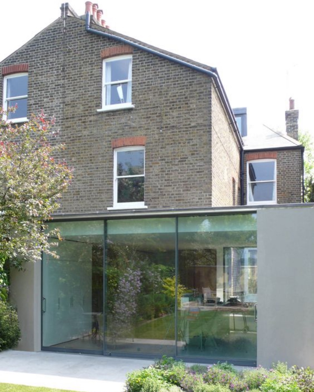 Frameless glass rear extension on a brick period house