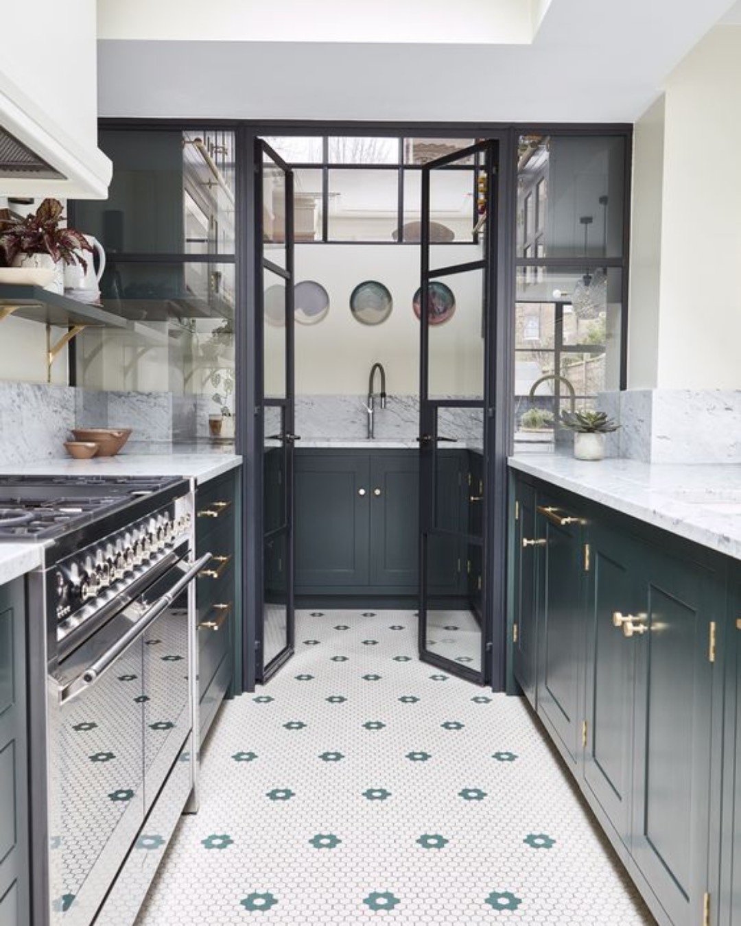 Galley kitchen with dark cabinets, marble worktops and steel-framed internal doors