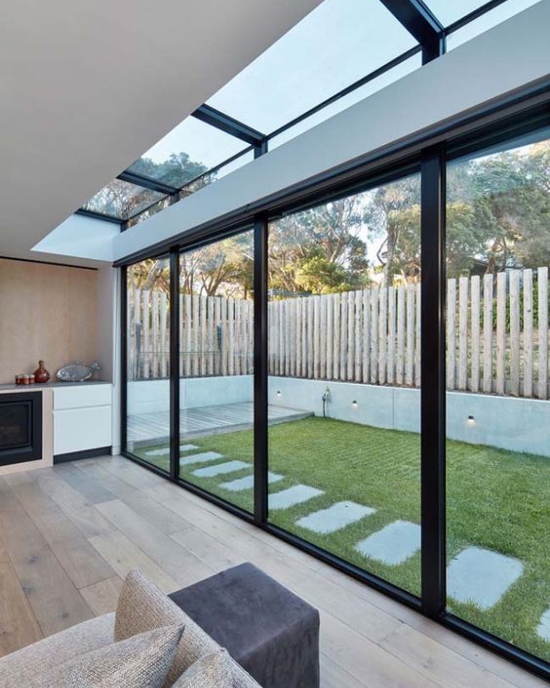 Kitchen extension with full-height glazed doors and a strip of roof glazing onto a lawn