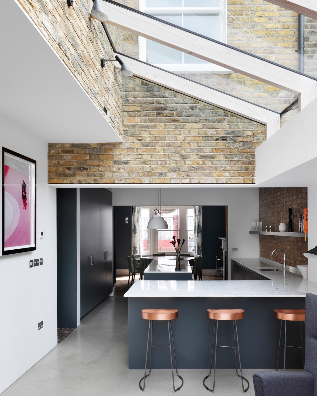 Glazed side return over an open-plan kitchen with exposed brick and a breakfast bar