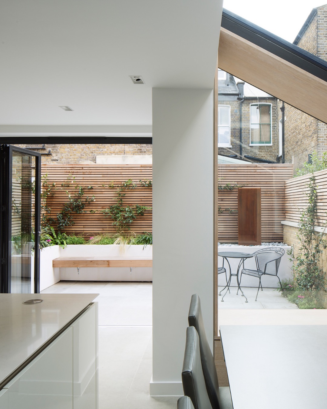 Open-plan extension with a structural column and glazing onto a courtyard garden