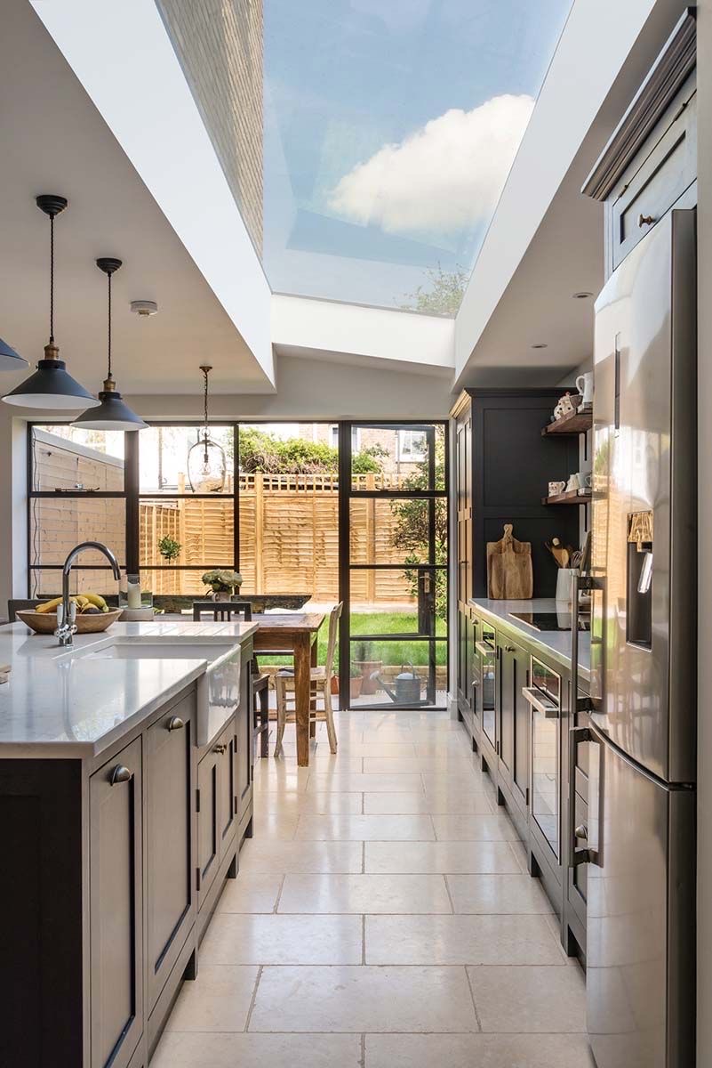 Side return kitchen with a glazed roof, steel-framed doors and a limestone floor