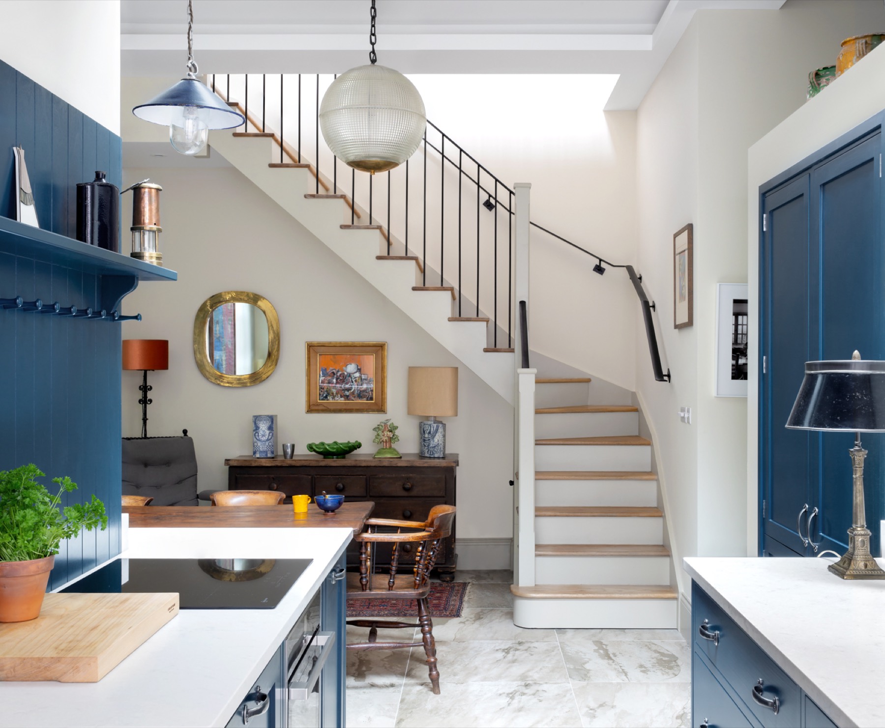 Painted blue kitchen opening onto a dining area and oak staircase, kitchen extension in Spitalfields and Wapping