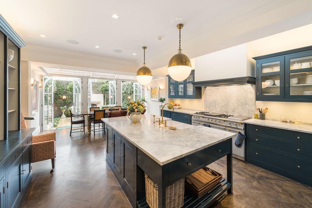 Kitchen with marble island opening onto the garden, kitchen extension in Upminster