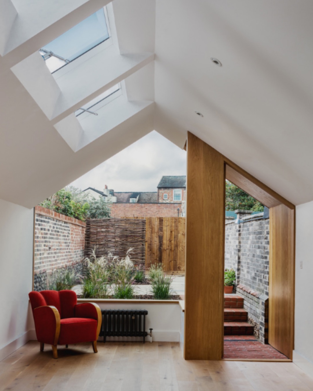 Vaulted extension with rooflights and a large pivot door onto a walled garden